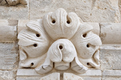Rosace en pierre sculptée sur mur calcaire